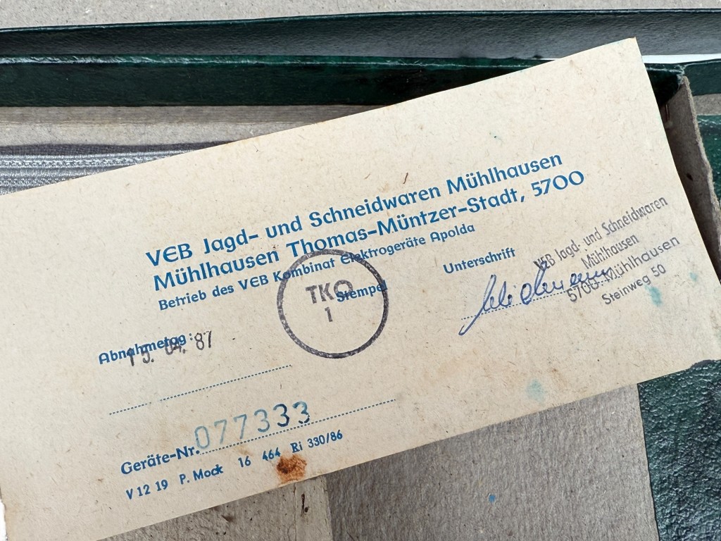 Detail of NVA officer dagger hilt with ivory grip, silver crossguard and original certificate from VEB Jagd- und Schneidwaren Mühlhausen – DDR collector’s item.