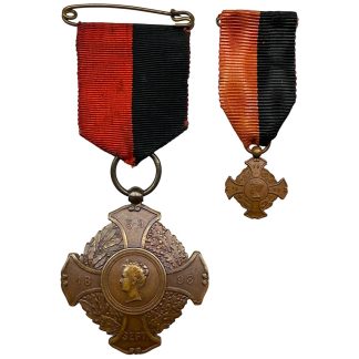 Origineel Herinneringskruis 1898 van de Amsterdamse Politie met bijbehorende miniatuur, uitgegeven ter gelegenheid van de inhuldiging van Koningin Wilhelmina op 5 september 1898. Bronzen medaille met rood-zwart lint, vervaardigd door Begeer, met portret van de jonge koningin en inscriptie “Hulde van Amstels Burgerij aan de Politie”. Zeldzaam Nederlands verzamelobject voor koninklijke en politiegerelateerde onderscheidingen.