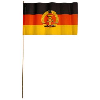 Originele DDR papieren vlag met houten stok uit de tijd van de Duitse Democratische Republiek, met zwart-rood-gele driekleur en staatswapen met hamer en passer – authentiek verzamelobject voor DDR en NVA verzamelaars.