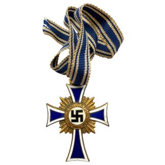 Original WWII German Mother’s Cross in Gold (Goldenes Mutterkreuz), featuring a blue-and-white enamel cross with a gold sunburst backing and a central swastika emblem, suspended from a blue-and-white striped ribbon. Historical Nazi-era award for mothers, shown in close-up detail.
