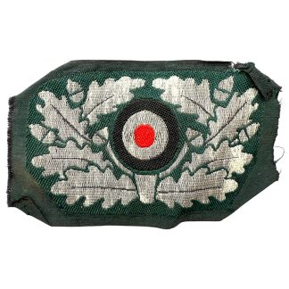 Original WWII German Wehrmacht (WH) flatwire officer’s visor cap cockade in mint condition, featuring silver oak leaf embroidery with red, white, and black roundel — authentic World War Two German insignia for militaria and WWII collectors.