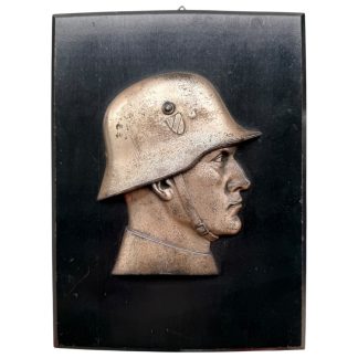 Original World War II German plaque with detailed metal relief portrait of soldier in helmet mounted on wooden board, 23.5 x 17.5 cm — authentic WWII militaria collectible for military history and plaque collectors.