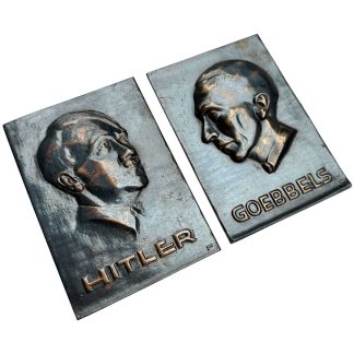 Original WWII-era German metal plaques manufactured by Carlshütte Rendsburg, featuring relief portraits of Adolf Hitler and Joseph Goebbels. Dark patinated finish with copper highlights, marked on the reverse with foundry stamp and original hanging cord. Authentic pre-war German militaria collectible for serious World War II collectors.