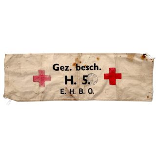 riginele Nederlandse Luchtbescherming Gezinsbescherming EHBO armband uit gemeente Voorburg, vooroorlogs 1939, met rode kruisen en stempel – WOII thuisfront militaria verzamelobject.