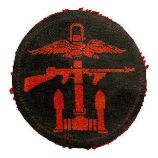 Original WWII British Commando printed cloth insignia patch with red winged anchor design on dark background, worn authentic special forces collectible.