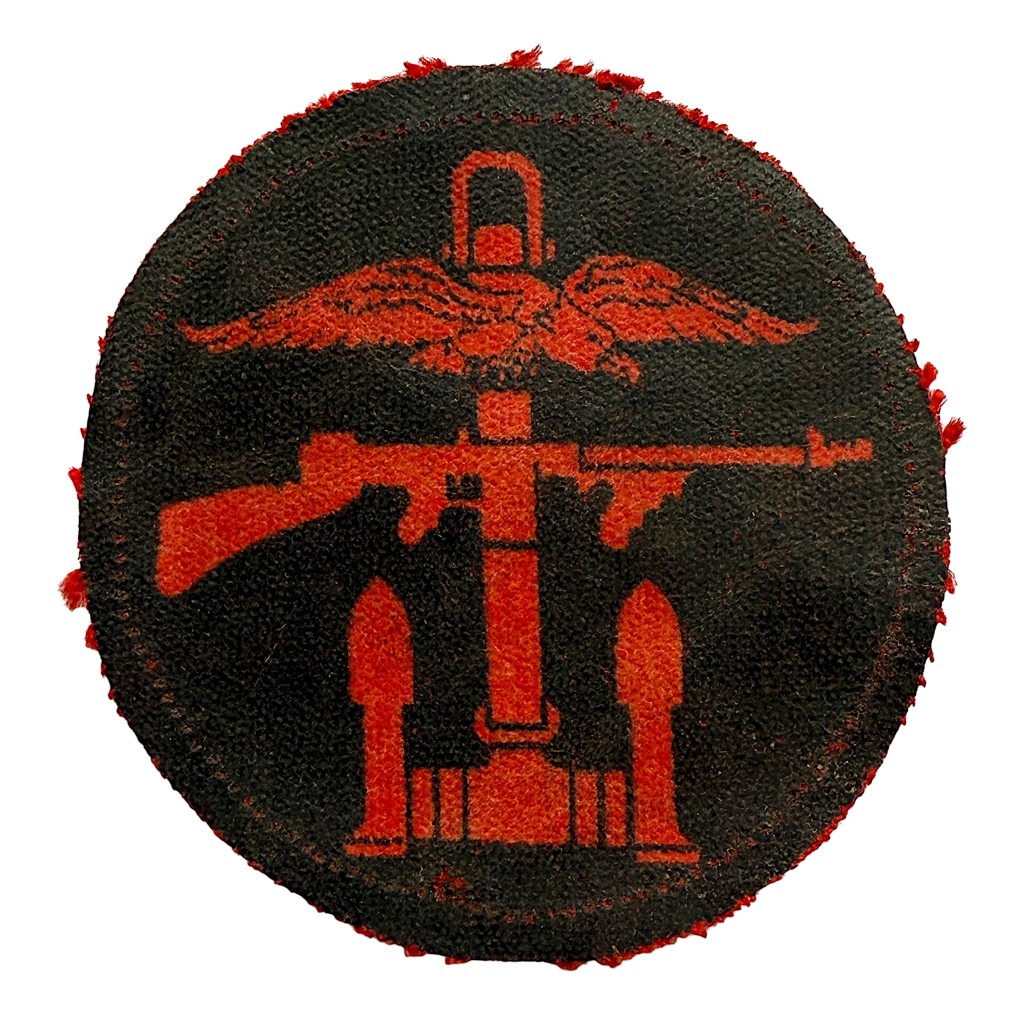 Original WWII British Commando printed cloth insignia patch with red winged anchor design on dark background, worn authentic special forces collectible.