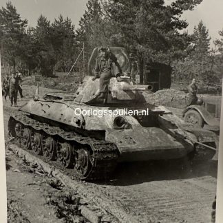 WW2 German photograph 1942 showing captured Soviet T-34/76 tank used by Wehrmacht on the Eastern Front, German soldier seated on muddy tank, Russia, original black and white wartime photo 9 x 6 cm