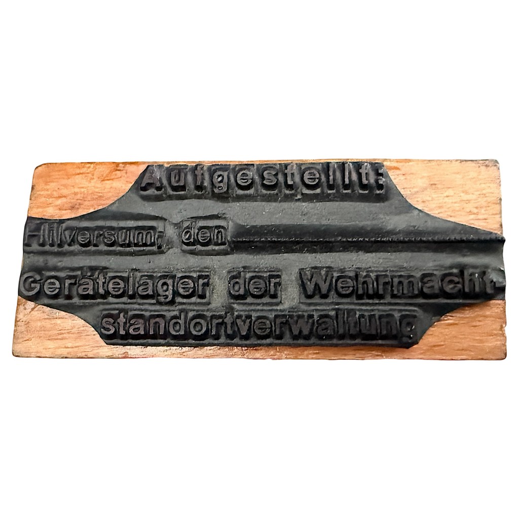 Originele Duitse Wehrmacht-stempel uit de Tweede Wereldoorlog (1940–1945), gebruikt tijdens de Duitse bezetting van Hilversum in Nederland. Houten stempel met zwarte handgreep en tekst “Ausgestellt: Hilversum – Gerätelager der Wehrmacht – Standortverwaltung”, historisch WOII-militaria verzamelobject met lokale bezettingsgeschiedenis van Hilversum.