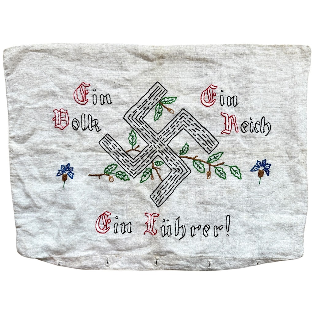 Authentic 1930s German embroidered pillowcase featuring oak leaves and the slogan “Ein Volk, Ein Reich, Ein Führer.” Original Nazi-era household textile, ideal for WWII militaria collectors, museums, and historical study. 56 × 40 cm.