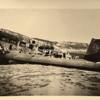 Oorspronkelijke Nederlandse WOII-foto van een neergestorte Duitse Junkers Ju 52 transportvliegtuig bij Kijkduin / Ter Heijde, Zuid-Holland, 1940. Historisch oorlogsfotografisch beeld met beschadigde romp en staart met Luftwaffe-markeringen, gefotografeerd op het strand tijdens de Tweede Wereldoorlog in de regio Den Haag.