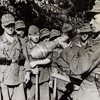 Original WWII German photograph of Panzerfaust training, German soldiers receiving anti-tank instruction from a combat veteran wearing the Silver Close Combat Clasp (Nahkampfspange), late-war Wehrmacht infantry training scene, official German press photo by Kriegsberichter Kurschat dated 8 July 1944, highly collectible German weapons training and militaria photograph, size 18 x 13 cm.