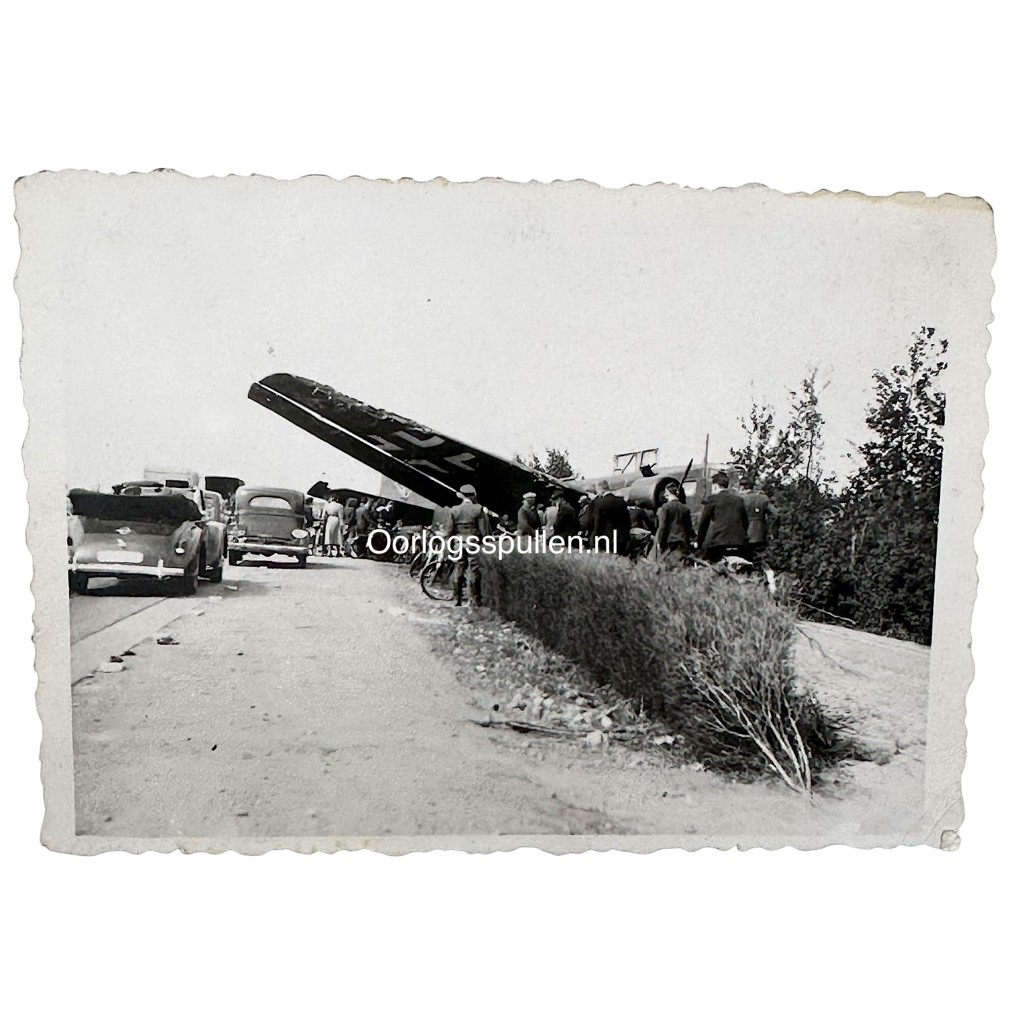 Meidagen 1940 foto van neergestort Duits vliegtuig in de omgeving van Rotterdam/Delft, met Nederlandse militairen en burgers bij het wrak tijdens de Duitse inval in Nederland – originele 9 x 6 cm Tweede Wereldoorlog foto, verzamelobject voor liefhebbers van mei 1940 fotografie.