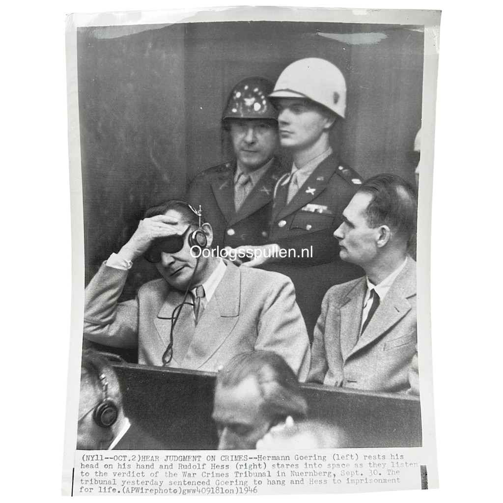 Original 1946 press photo of the Nuremberg Trials showing Hermann Göring with headphones and Rudolf Hess listening to the verdict of the International Military Tribunal in Nuremberg, Germany – WWII war criminals courtroom scene, 24 x 18 cm vintage photograph with Cleveland News stamp on verso.