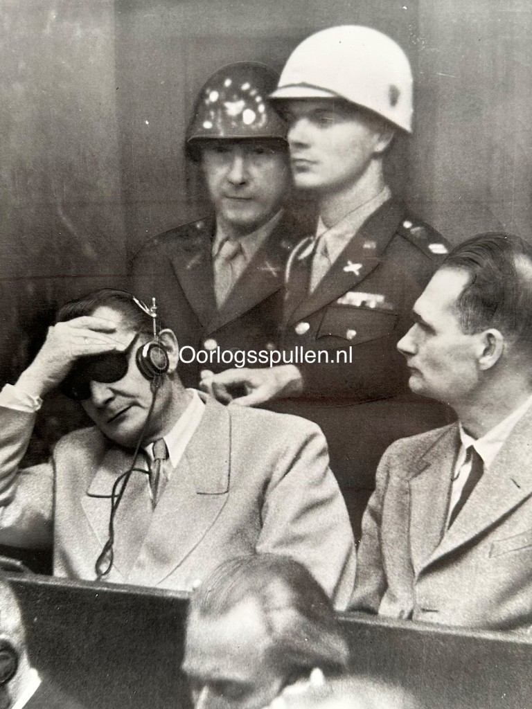 Original 1946 press photo of the Nuremberg Trials showing Hermann Göring with headphones and Rudolf Hess listening to the verdict of the International Military Tribunal in Nuremberg, Germany – WWII war criminals courtroom scene, 24 x 18 cm vintage photograph with Cleveland News stamp on verso.