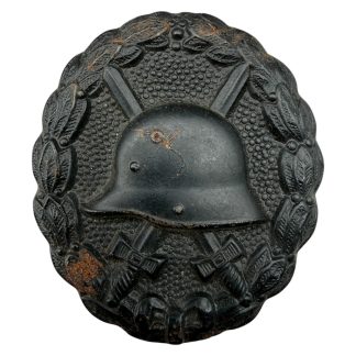 Original German wound badge black WW1 helmet crossed swords laurel wreath collector item.