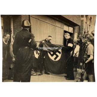 Originele WWII foto Nederlandse Binnenlandse Strijdkrachten NBS Rotterdam 1945 met buitgemaakte Duitse hakenkruisvlag tijdens bevrijding.