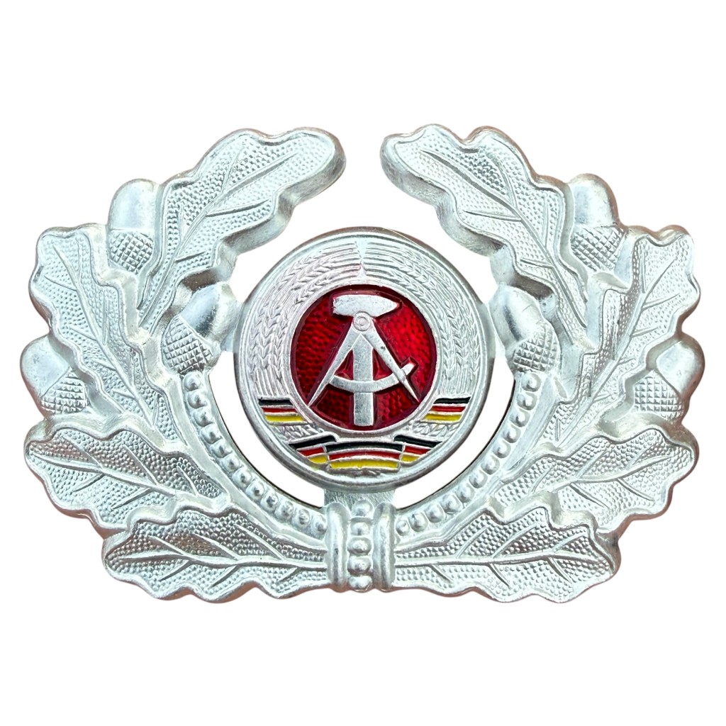 Originele DDR NVA kokarde met eikenloofkrans voor Schirmmütze vizierpet Koude Oorlog Oost-Duitse militaria.