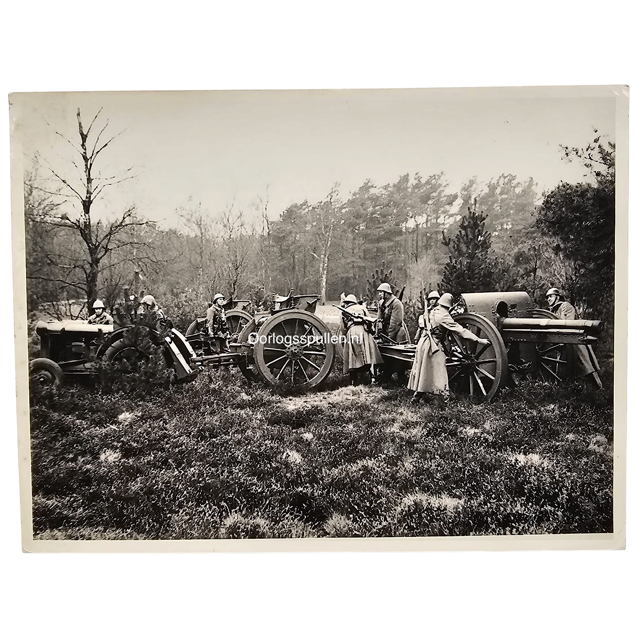 Originele Pre 1940 Nederlandse legerfoto met artillerie, veldgeschut, militairen met Nederlandse helmen en artillerietrekker tijdens veldoefening.
