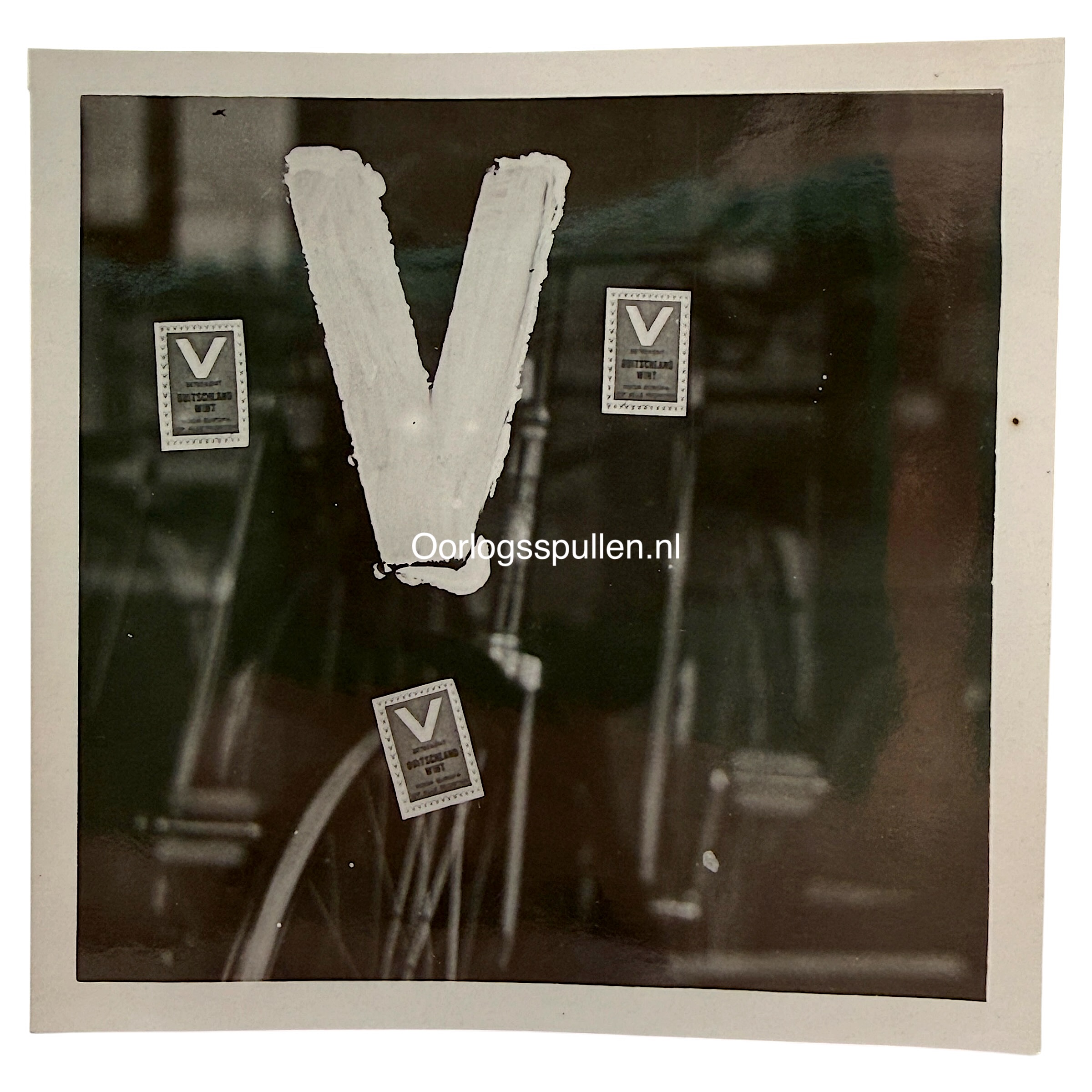 Originele WWII Duitse foto NSB V-actie op etalageruit van fietsenwinkel in Den Haag tijdens de Duitse bezetting van Nederland.