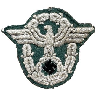Original WWII German Polizei officer sleeve eagle bullion insignia with silver embroidery on dark green cloth and black enamel swastika.