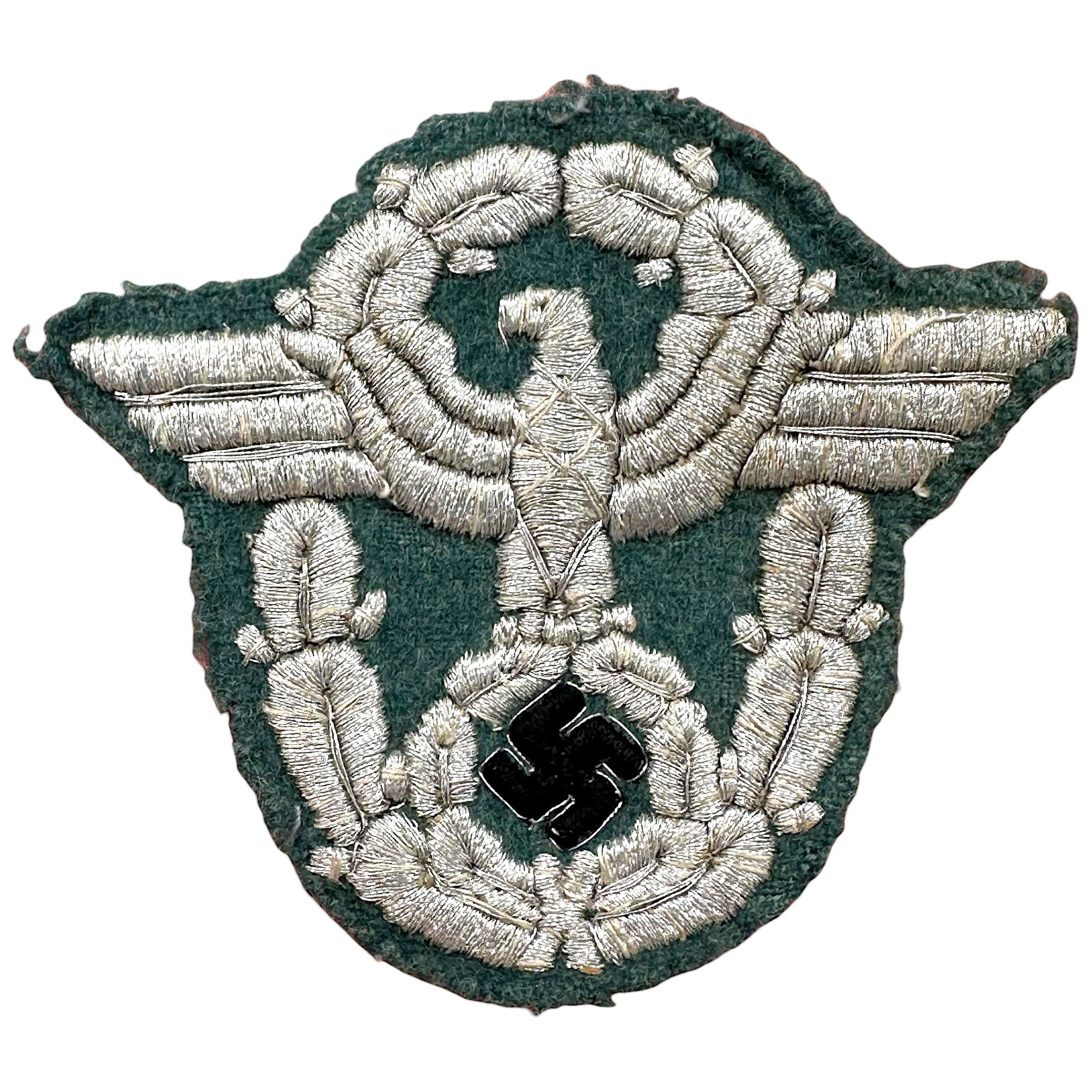 Original WWII German Polizei officer sleeve eagle bullion insignia with silver embroidery on dark green cloth and black enamel swastika.