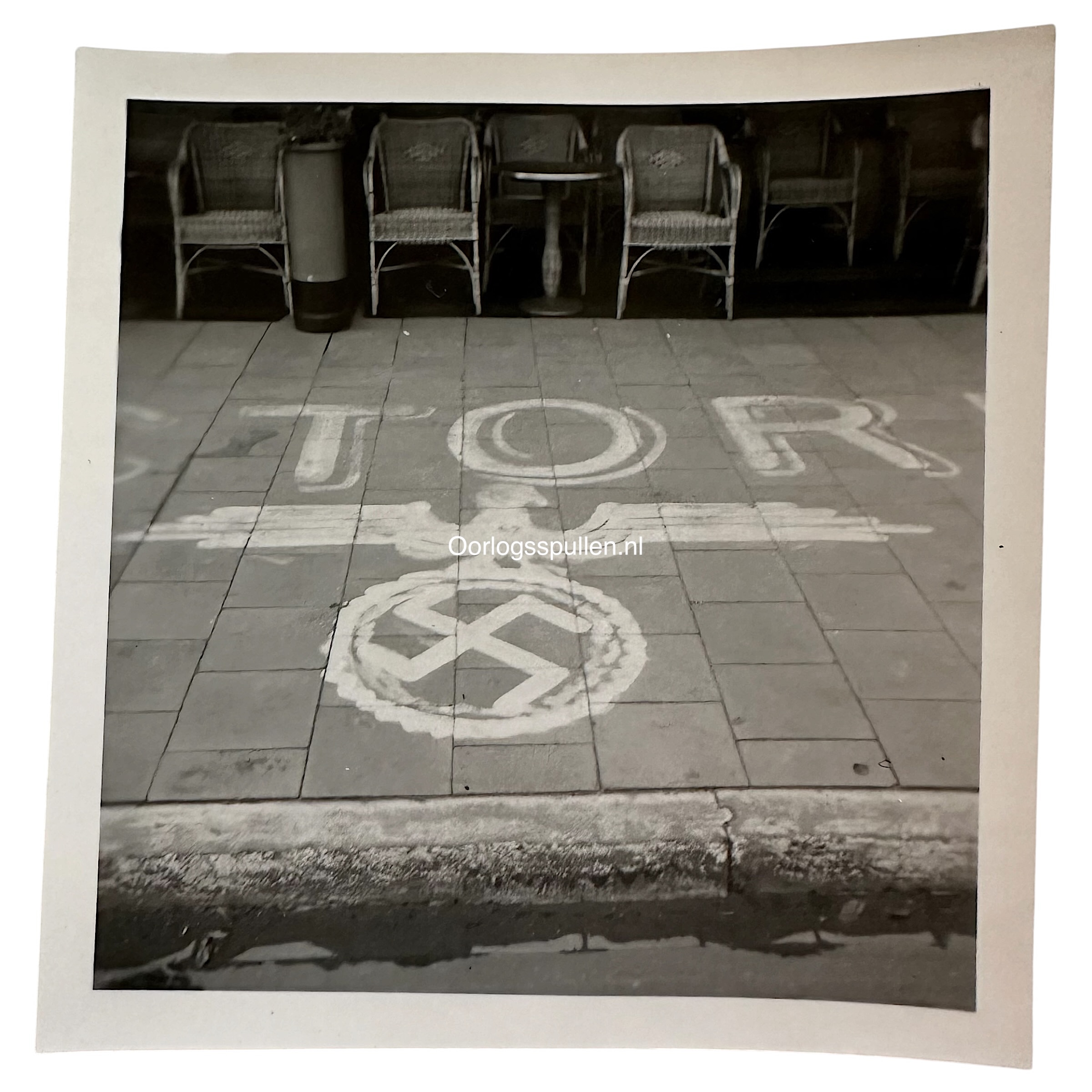 Originele WWII foto van een terras in Den Haag met een geschilderd hakenkruis op de stoep